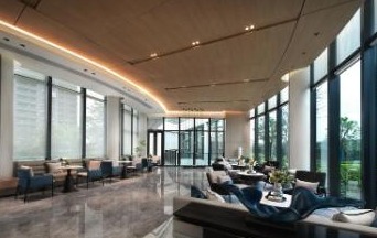 Geniş cam cepheli, modern bir otel lobisi oturma alanı